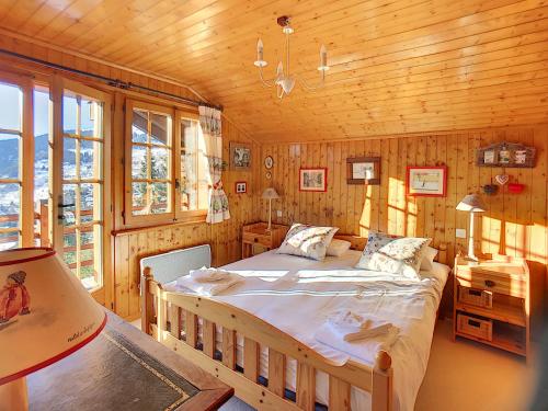 ein Schlafzimmer mit einem Bett in einer Holzhütte in der Unterkunft Apartment Summit Combles in Verbier
