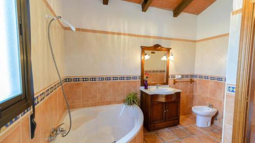 y baño con bañera, lavabo y aseo. en Casa Rural El Guindo en Málaga