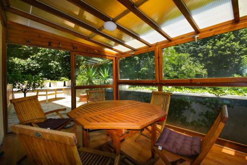 - une terrasse couverte avec une table et des chaises en bois dans l'établissement La VILLA ILIXON, à Luchon