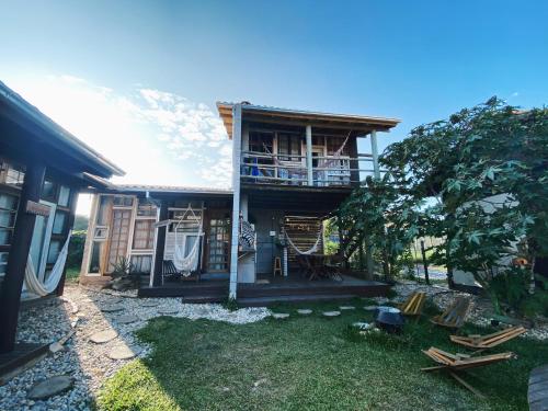 a house with a balcony and a yard at Recanto do Xamã - Praia do Rosa in Praia do Rosa