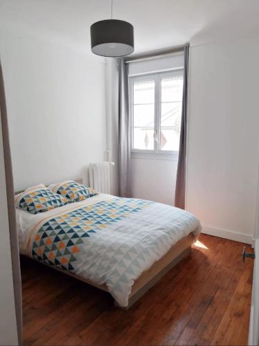 a bedroom with a bed with a window and wooden floors at Bel appartement ancien Poitiers Centre - 4 Chambres in Poitiers