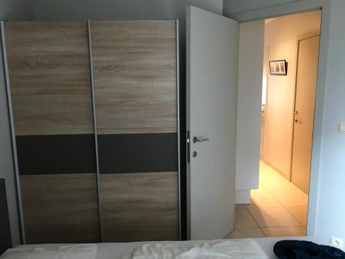 a closet with a wooden door in a bedroom at Appartement Koksijde in Koksijde