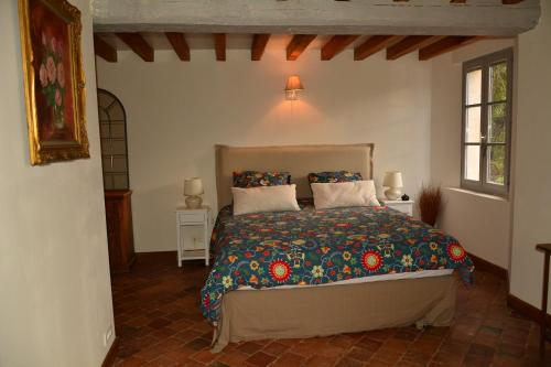 1 dormitorio con 1 cama y 2 ventanas en Le Vieux Saule en Saints