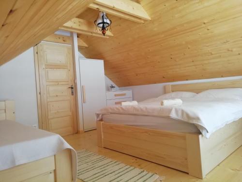 a bedroom with a bed and a wooden ceiling at Domček Michaela in Zuberec