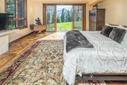 een slaapkamer met een groot bed en een groot tapijt bij Beehive Basin Chalet in Big Sky