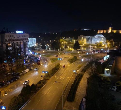 a city street at night with cars on the road at 3M Apartment Skopje Center in Skopje