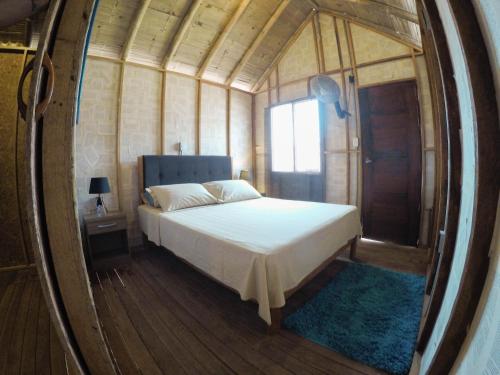 a bedroom with a bed in a round mirror at Wild Rover Beach Mancora in Máncora
