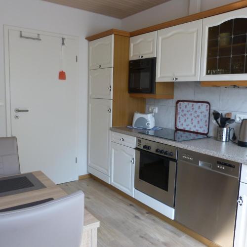 a kitchen with white cabinets and stainless steel appliances at Zur Amsel in Damnatz