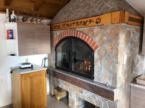 een grote stenen open haard in een keuken bij Apartmani Turalija in Kupres