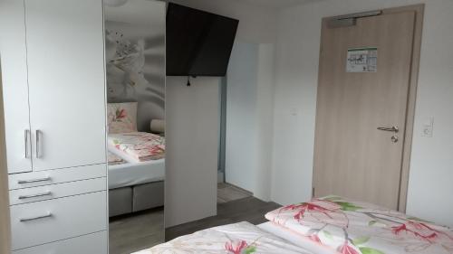 a bedroom with a bed and a closet with a mirror at Gästehaus - Café Frank in Antweiler