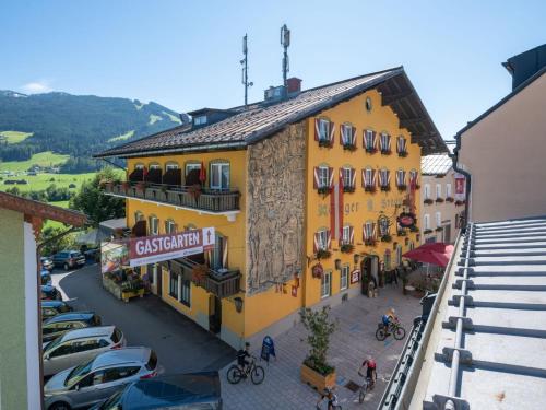 Un edificio amarillo con coches aparcados en un estacionamiento. en Hotel Stegerbräu, en Radstadt