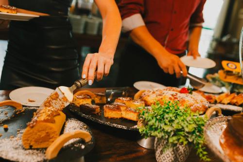 a person preparing food on a table at Villa Verde Hotel in Avaré