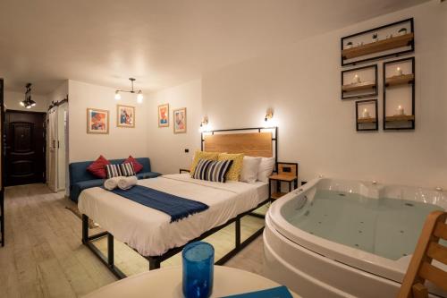 a bedroom with a tub and a bed and a couch at Jacuzzi By The Historic Giza Pyramids - Apartment 3 in Cairo