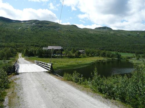 een brug over een rivier naast een weg bij Jønndalen Høyfjellseter in Uvdal