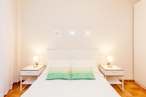 1 dormitorio con 1 cama blanca y 2 mesitas de noche en TU DESCANSO, en San José