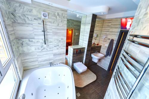 a large bathroom with a tub and a toilet at Sauna, Big Jacuzzi , Khreshchatyk apartments in Kyiv