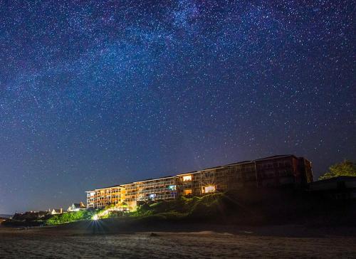 a building on the beach under a starry sky at Hallmark Resort in Cannon Beach in Cannon Beach