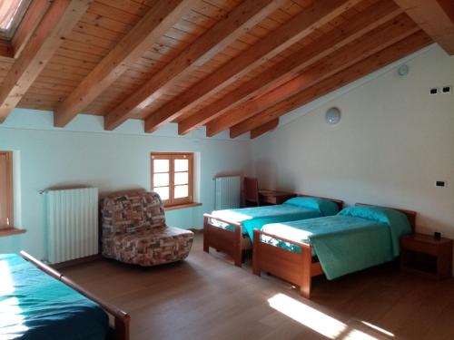 a room with two beds and a couch and a chair at Ca' del Laki in Caprino Veronese
