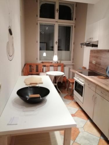 齊陶的住宿－Wohnung im historischen Altbau von 1899，柜台上有一个黑碗的厨房