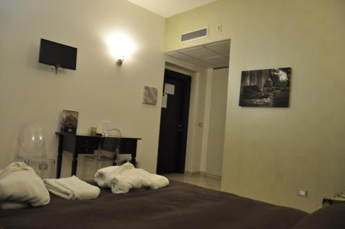 a bedroom with a bed with towels on it at Regalpetra Hotel in Racalmuto