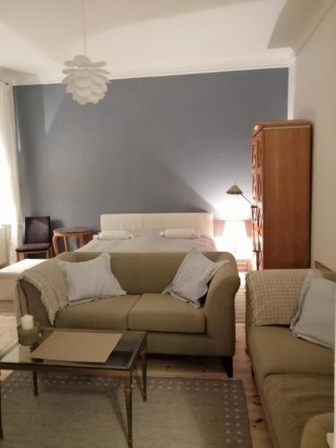 een woonkamer met een bank en een bed bij Ruhe des Nordens Appartement in Zittau