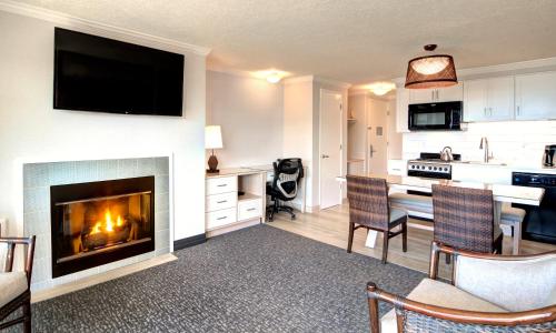 a living room with a fireplace and a kitchen at Hallmark Resort in Cannon Beach in Cannon Beach