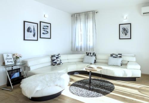 a living room with a white couch and a table at Iris beach apartments in Kaštela