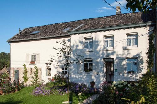 een wit huis met bloemen ervoor bij PuurTeuven B&B tussen Kunst en Natuur in Voeren