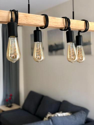 a group of lights hanging from a beam in a living room at (L.I.H.8) Luxury Industrial House 8 in Nea Paphos