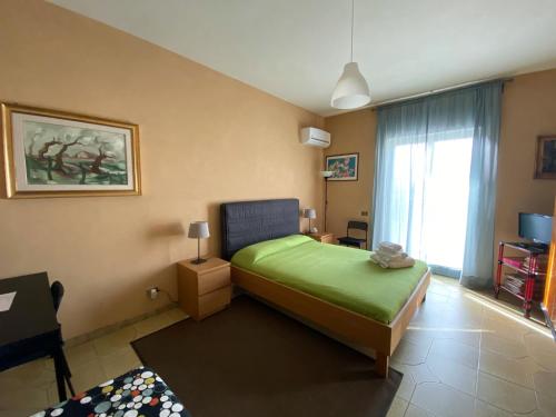 a bedroom with a green bed and a window at Terra Di Mare in Agrigento