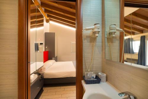 a bathroom with a sink and a bed in a room at Hotel Fontana Verona in Verona