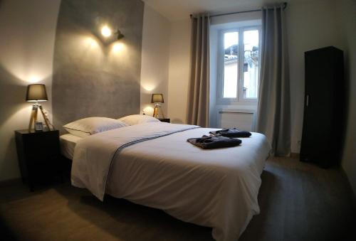 a bedroom with a large white bed with a window at Wanderlust Anduze in Anduze