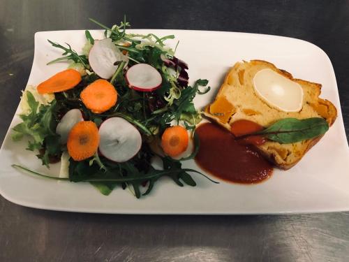 a plate of food with a salad and a sandwich at Logis Hôtel Restaurant Les Aubuns in Caissargues