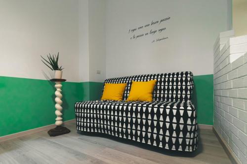 a black and white couch with two yellow pillows on it at Acchiappasogni Holiday House in Malgrate