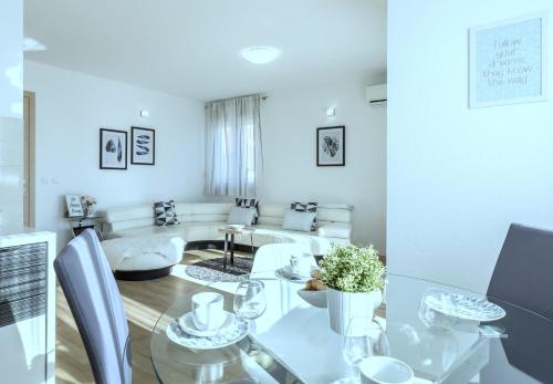 a dining room and living room with a glass table at Iris beach apartments in Kaštela