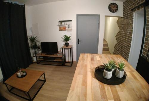 ein Wohnzimmer mit einem Holztisch mit Pflanzen darauf in der Unterkunft Wanderlust Anduze in Anduze