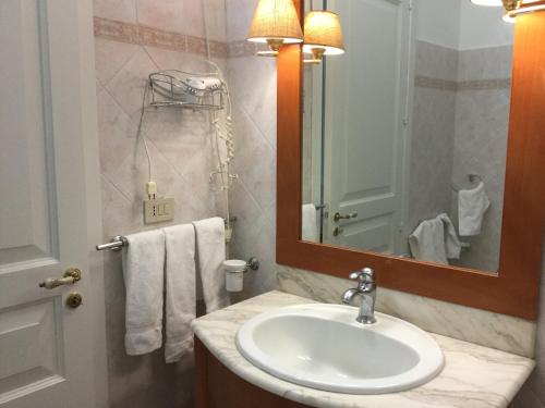 a bathroom with a sink and a mirror and towels at Crispi Accomodation in Catania