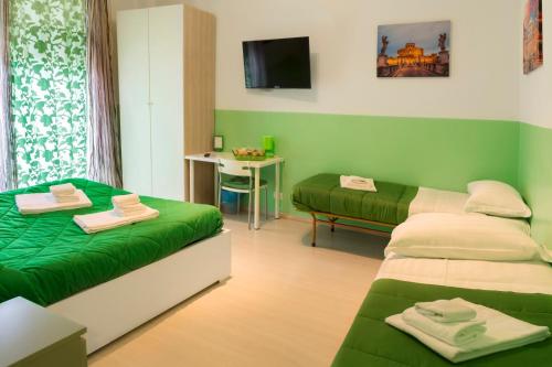 a green room with two beds and a table at The Colours Of Rome in Rome