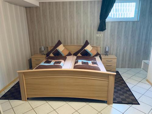 a bedroom with a large wooden bed with pillows at Ferienwohnung Hochwaldblick 3 in Morbach