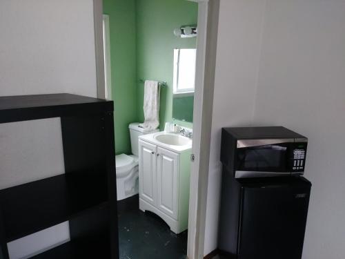 a bathroom with a white toilet and a sink at Portland Pensione in Portland