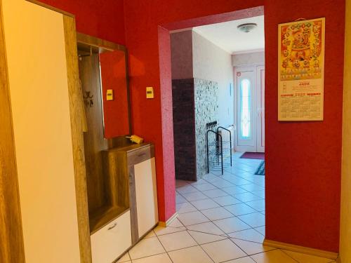 a hallway with red walls and a tile floor at Ferienwohnung Hochwaldblick 3 in Morbach
