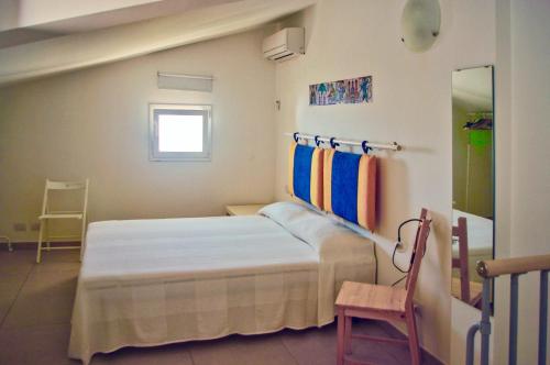 a small bedroom with a bed and a chair at Terrazza Montalbano in Punta Secca
