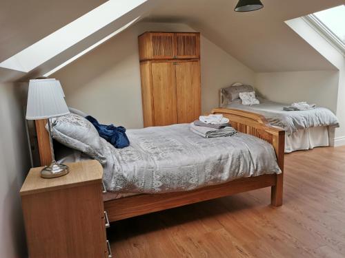 a bedroom with two beds and a table with a lamp at Slievescape in Newry