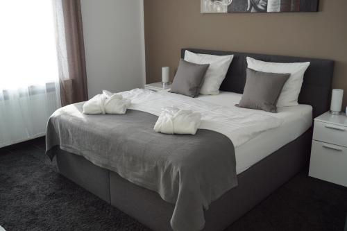 Un dormitorio con una cama grande con dos zapatos blancos. en La Domus Superior Osnabrück Lotte, en Osnabrück
