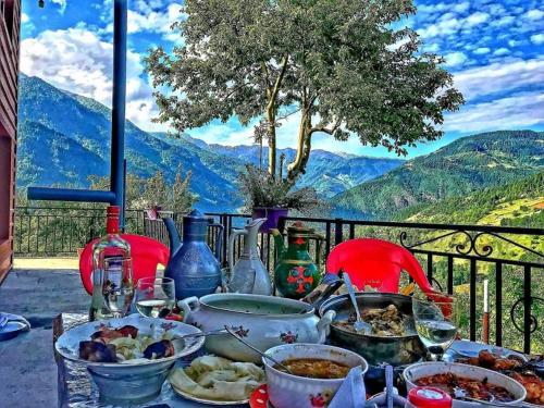 a table full of food with a view of mountains at Luka House in Akhaldaba