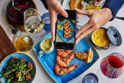 a person taking a picture of a plate of food at Fairmont Rio de Janeiro Copacabana in Rio de Janeiro