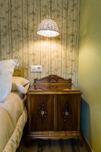a bedroom with a bed and a nightstand with a lamp at Hospedium Hotel El Nido de Alcudia Suites in Almodóvar del Campo