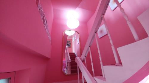 a pink room with stairs and a light on the ceiling at Spring Light in Seoul