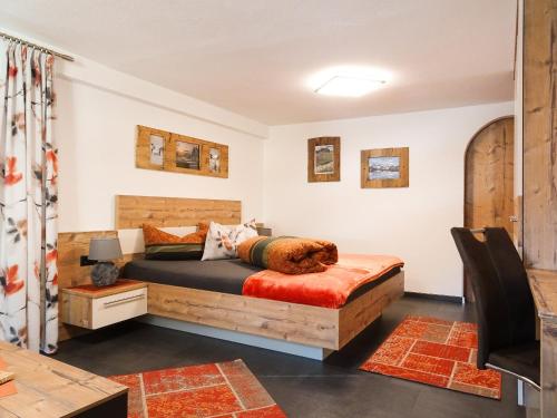 a bedroom with a wooden bed and a table at Ferienwohnung Lederle Maria-Luise in Jerzens