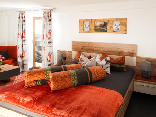 een slaapkamer met een groot bed met oranje kussens bij Ferienwohnung Lederle Maria-Luise in Jerzens